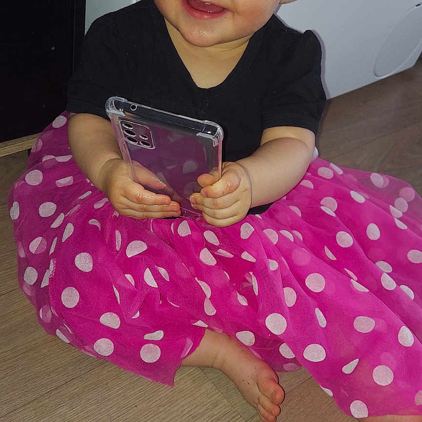 Kaycy participe au concours pour gagner de l'argent avec cette photo : appliance, baby, bodypart, clothing, device, dress, electricaldevice, electronics, face, finger, hand, head, mobilephone, person, phone, photography, portrait, sitting, washer, wood