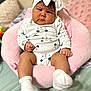 Kataleya Toro is registered to the contest to win money with this photo: baby, infant, headband, bow, onesie, socks, pink_cushion, soft_furniture, serious_expression, indoor, child, cute, portrait, plush, sitting, person, cozy, comfortable, skin, young_child