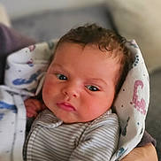 Bianca is registered to the contest to win money with this photo: baby, blanket, closeup, clothing, cozy, curious, cute, expression, face, hand, holding, indoor, infant, nail_polish, newborn, person, portrait, skin, soft_lighting, striped