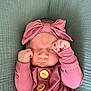 baby, newborn, sleeping, pink_outfit, headband, bow, wooden_buttons, fists, close_up, soft_blanket, infant, cute, peaceful, portrait, child, resting, indoors, cozy, tiny_hands, fabric_texture