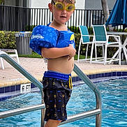 Ryder Lee is registered to the contest to win money with this photo: child, pool, swimming, goggles, floaties, water, outdoor, summer, boy, batman, swim_trunks, safety, playful, fun, vacation, holiday, leisure, blue, yellow, water_sports
