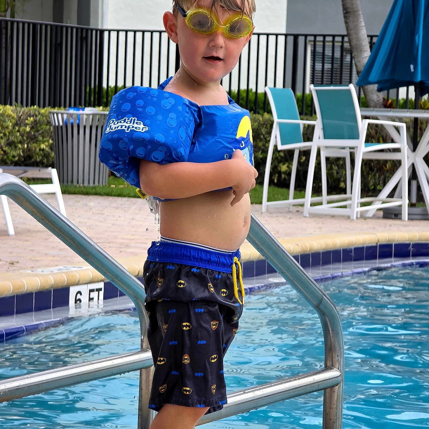 Ryder Lee is registered to the contest to win money with this photo: child, pool, swimming, goggles, floaties, water, outdoor, summer, boy, batman, swim_trunks, safety, playful, fun, vacation, holiday, leisure, blue, yellow, water_sports