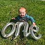 Asher is registered to the contest to win money with this photo: toddler, child, grass, balloon, silver_balloon, outdoor, smile, happy, birthday, one, overalls, shirt, sunlight, celebration, greenery, nature, young_child, cute, joyful, playing