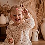Lou participe au concours pour gagner de l'argent avec cette photo : toddler, child, smiling, lollipop, pigtails, indoor, home_decor, vase, dried_plants, cute, happy, portrait, warm_lighting, cozy, playful, white_clothing, patterned_dress, person, young_child, fun