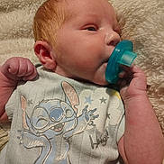 Adam joined the competition — help win amazing prizes! baby, infant, pacifier, red_hair, clothing, cartoon_character, blanket, soft_texture, sleepy, cute, hand, face, skin, indoors, portrait, newborn, baby_garment, comfort, resting, child