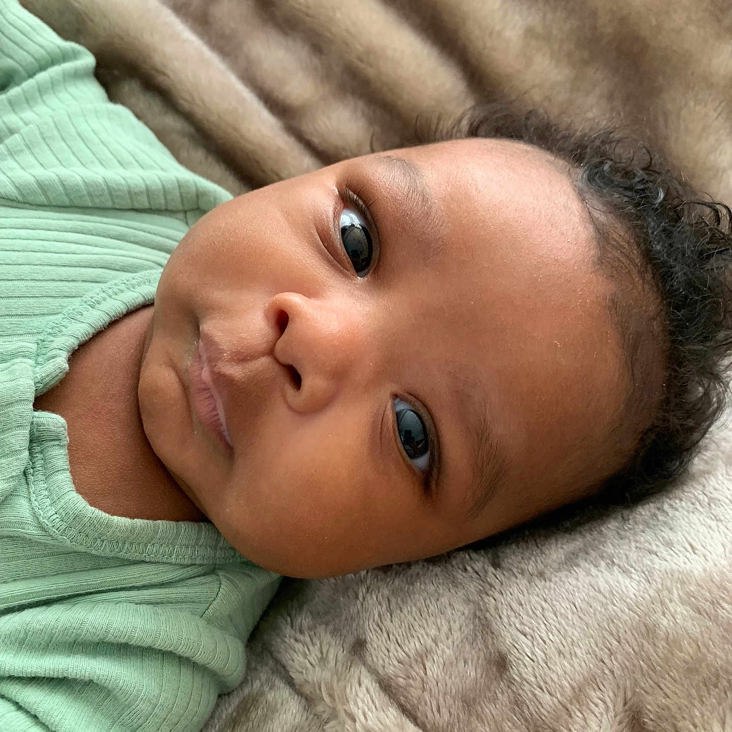 Ryan joined the competition — help win amazing prizes! baby, infant, face, eyes, expression, skin, clothing, blanket, texture, soft, closeup, portrait, curly_hair, young_child, cute, lying_down, indoor, sleepwear, child, person