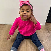 Paitynn is registered to the contest to win money with this photo: toddler, child, pink_bow, pink_top, blue_jeans, socks, wooden_floor, indoor, cute, smiling, sitting, person, headband, baby, portrait, young_child, casual_clothing, flooring, happy, playful
