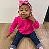 toddler, child, pink_bow, pink_top, blue_jeans, socks, wooden_floor, indoor, cute, smiling, sitting, person, headband, baby, portrait, young_child, casual_clothing, flooring, happy, playful