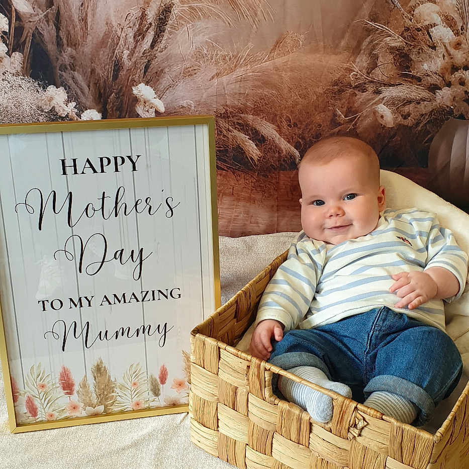 Charlie joined the competition — help win amazing prizes! baby, basket, bed, box, clothing, couch, face, furniture, glove, head, jeans, newborn, pants, person, photography, portrait, sitting, text, whiteboard, wood