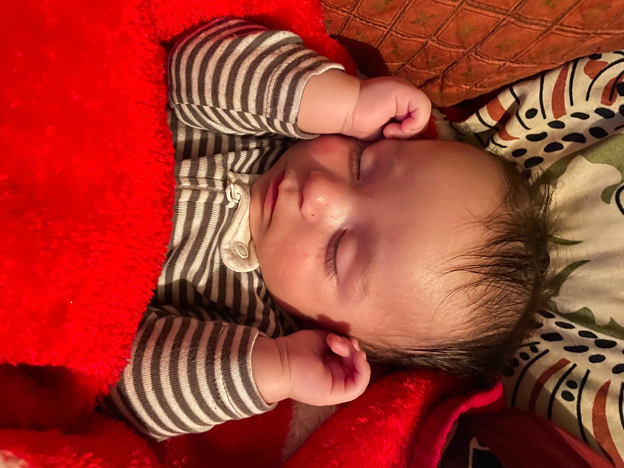 Amy is registered to the contest to win money with this photo: arm, baby, cheek, comfort, eye, eyelash, face, facial_expression, finger, hand, head, human_body, iris, leg, lip, mouth, nose, orange, person, product