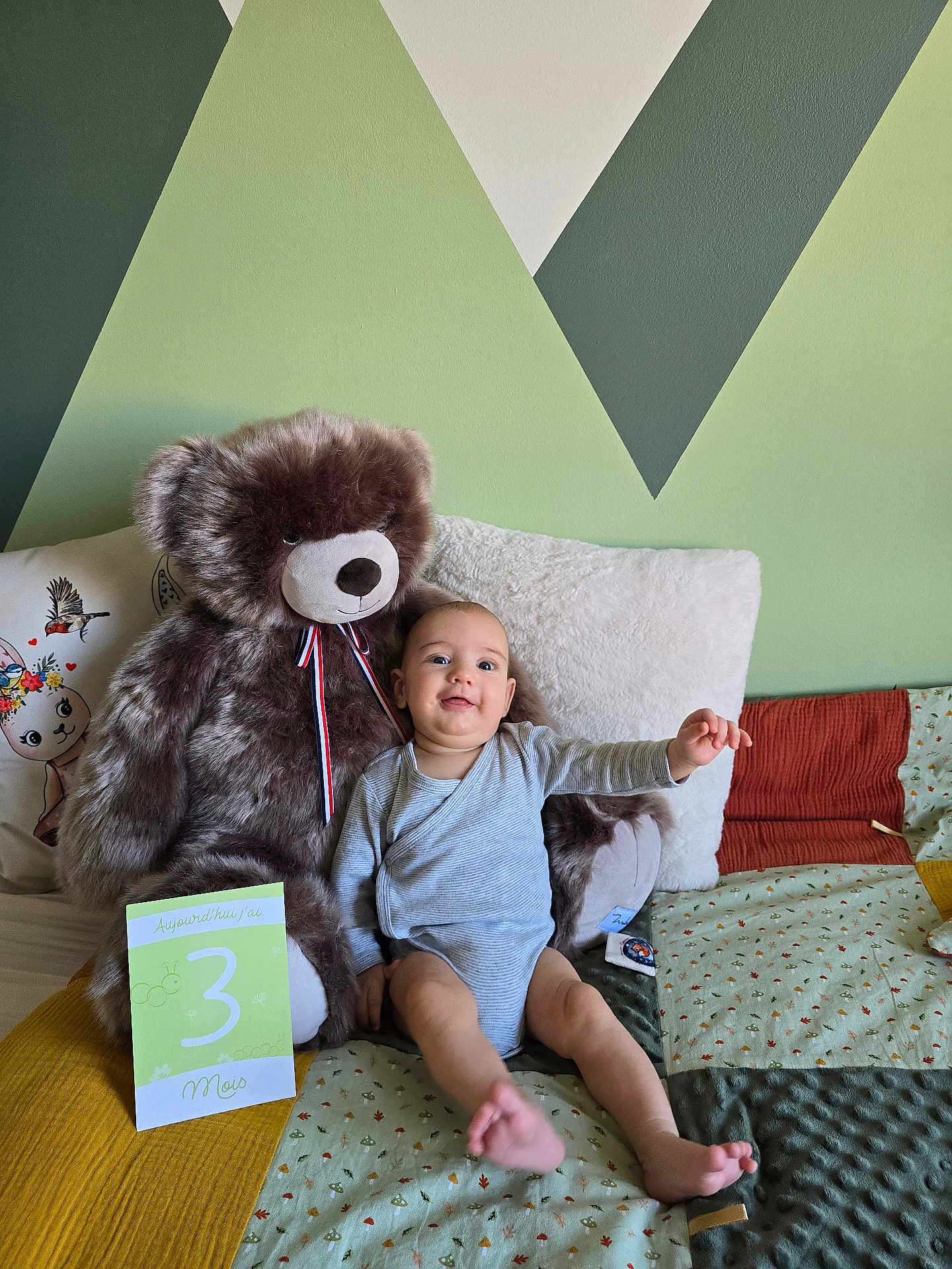 Charlie participe au concours pour gagner de l'argent avec cette photo : baby, teddy_bear, bed, pillow, blanket, milestone_card, wall_art, child, infant, smiling, indoor, soft_toy, clothing, furniture, person, cute, happy, sitting, portrait, home