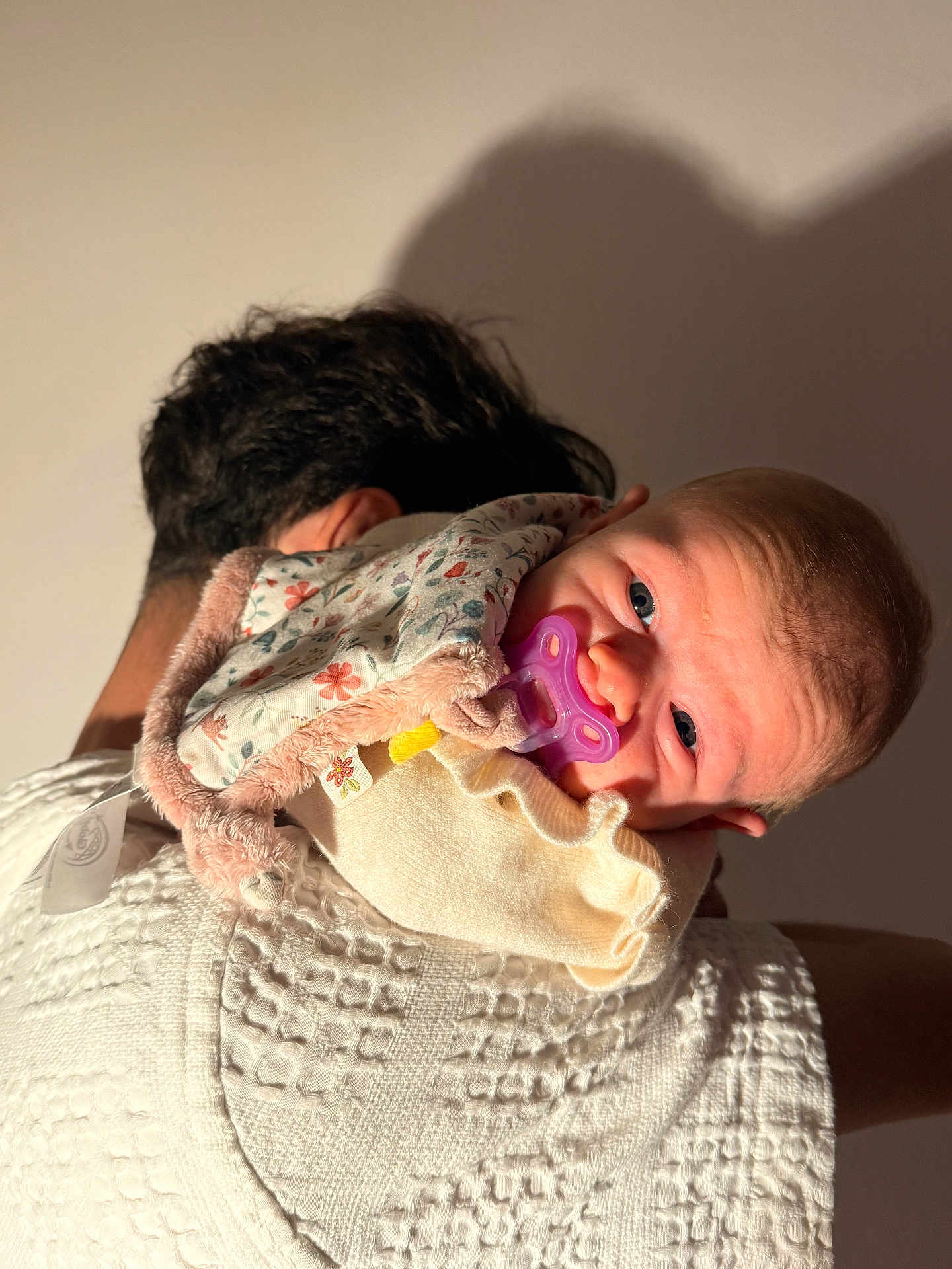 Noémie participe au concours pour gagner de l'argent avec cette photo : baby, infant, pacifier, blanket, person, shoulder, face, blue_eyes, soft_light, shadow, floral_pattern, clothing, closeup, skin, head, newborn, comfort, cuddle, warmth, portrait