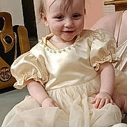 Diana participe au concours pour gagner de l'argent avec cette photo : baby, child, smiling, dress, puffy_sleeves, sitting, indoor, happy, face, hair, footwear, shoes, floor, bag, wall, decor, person, portrait, clothing, cute