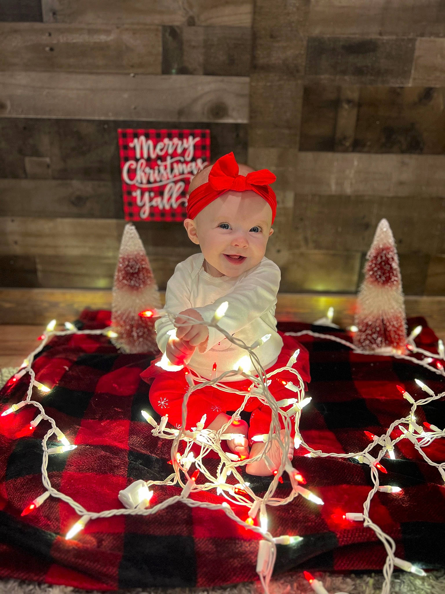 Sophie joined the competition — help win amazing prizes! baby, carmine, christmas, christmas_decoration, christmas_eve, christmas_ornament, costume_hat, event, fictional_character, fur, hat, headgear, headwear, holiday, person, santa_claus, sitting, toddler, tradition, tree