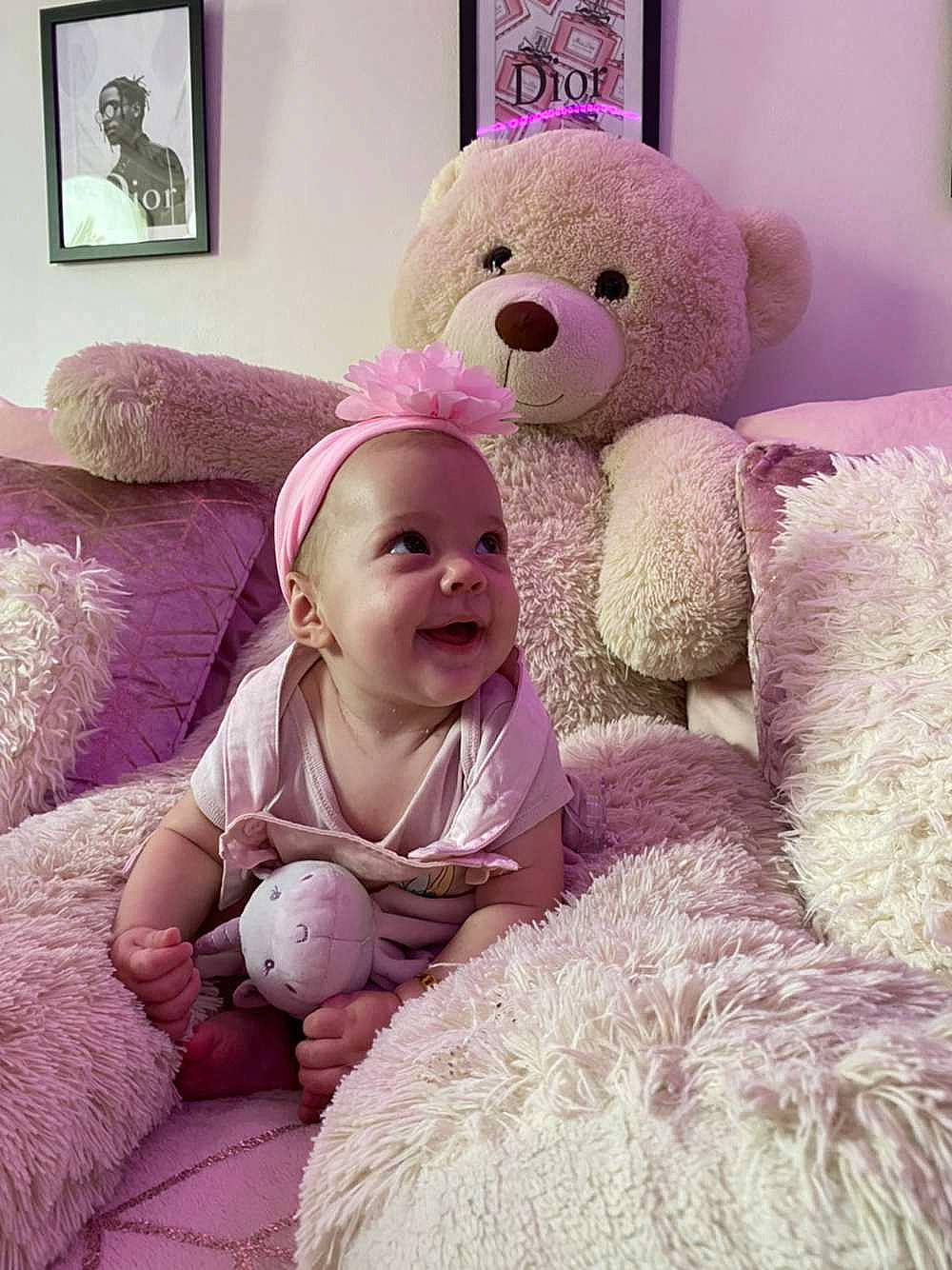 Kellya a rejoint le concours — aidez-le/la à gagner de superbes lots ! baby, baby_toddler_clothing, comfort, couch, happy, linens, magenta, mammal, person, picture_frame, pink, purple, skin, smile, stuffed_toy, teddy_bear, textile, toddler, toy, violet