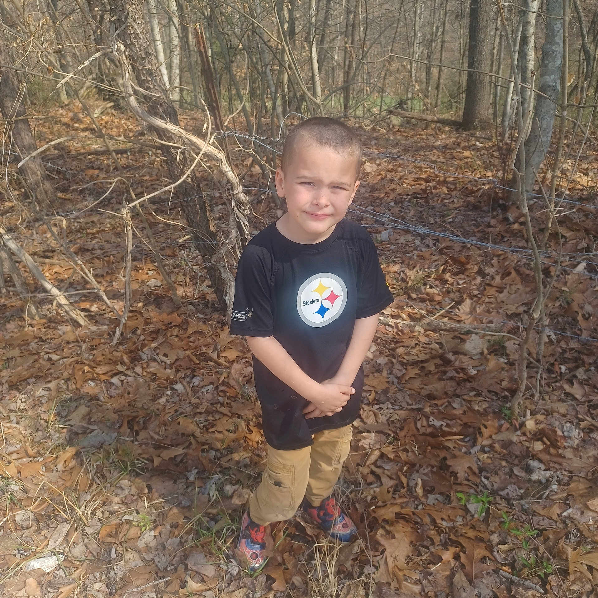 Rk joined the competition — help win amazing prizes! child, boy, forest, leaves, trees, outdoor, sunlight, pants, tshirt, sports_logo, fence, nature, standing, casual_clothing, young, candid, daylight, expression, bare_trees, ground_cover
