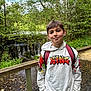 Kelyan participe au concours pour gagner de l'argent avec cette photo : child, boy, hoodie, backpack, bridge, waterfall, forest, trees, nature, stream, outdoor, casual, young, smile, greenery, wood, water, scenic, person, daylight