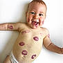 baby, diaper, face, smile, tongue_out, lipstick_marks, skin, arm, chest, lying_down, cute, infant, expression, happy, child, person, playful, white_background, closeup, portrait