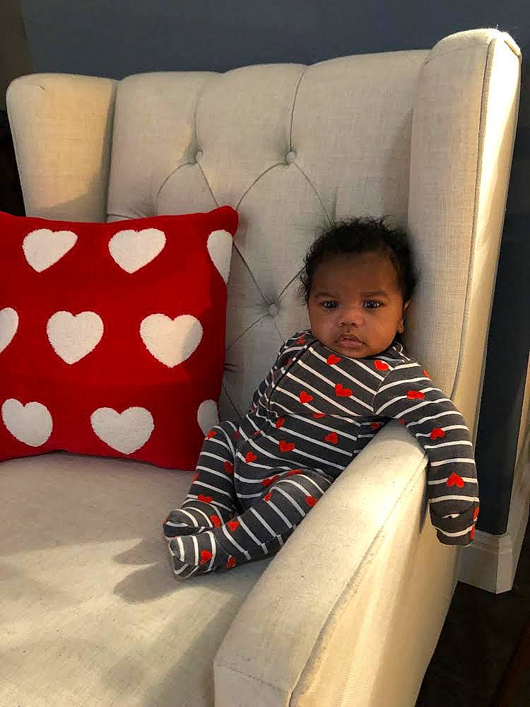Keith Jr is registered to the contest to win money with this photo: baby, baby_toddler_clothing, beauty, black, carmine, chair, comfort, couch, face, flooring, living_room, pattern, person, pillow, rectangle, room, sleeve, studio_couch, textile, throw_pillow