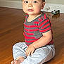 Zachary joined the competition — help win amazing prizes! toddler, child, sitting, wooden_floor, striped_shirt, gray_pants, barefoot, indoor, toy_car, curious_expression, person, young_child, casual_clothing, home, flooring, playtime, cute, portrait, smiling, baby
