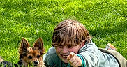 Milo a rejoint le concours — aidez-le/la à gagner de superbes lots ! boy, dog, grass, outdoor, pet, child, playing, smiling, casual_clothing, greenery, sunlight, happy, leash, nature, friendship, relaxing, summer, fun, animal, portrait