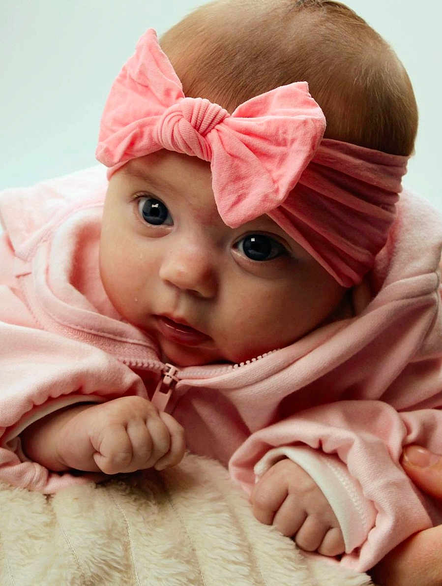 Mazikeen joined the competition — help win amazing prizes! baby, infant, pink_bow, headband, pink_clothing, cute, child, close_up, portrait, hand, soft_texture, fluffy, cozy, young_child, skin, eyes, face, expression, adorable, newborn