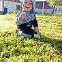 Teo participe au concours pour gagner de l'argent avec cette photo : baby, child, grass, hoodie, outdoor, smiling, happy, sunlight, nature, person, greenery, yard, casual_clothing, sitting, daylight, playful, cute, young_child, face, grass_field