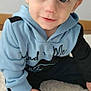 Teo a rejoint le concours — aidez-le/la à gagner de superbes lots ! toddler, child, blue_eyes, hoodie, socks, carpet, indoor, smile, cute, baby, person, portrait, clothing, sitting, young_child, hand, floor, face, light, casual