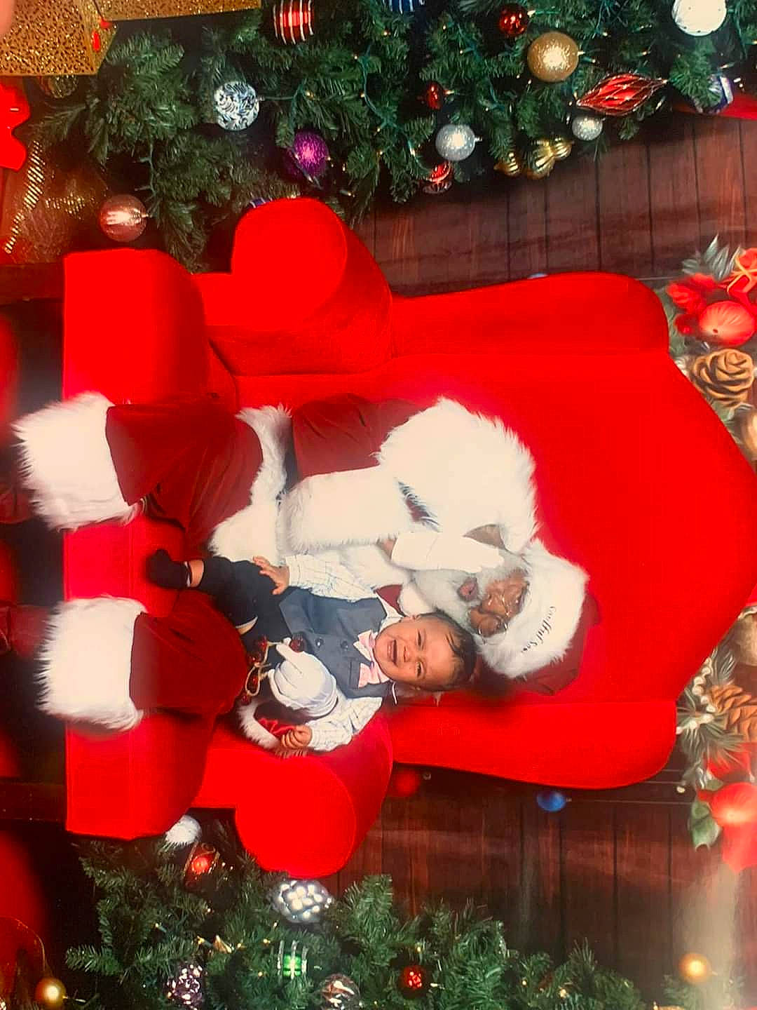 Kyrie is registered to the contest to win money with this photo: christmas, christmas_decoration, christmas_eve, christmas_ornament, christmas_tree, event, green, holiday, holiday_ornament, human_body, lap, light, ornament, person, plant, red, room, santa_claus, sorrow, tree