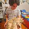 Leonore a rejoint le concours — aidez-le/la à gagner de superbes lots ! person, cat, indoor, smiling, striped_shirt, tom_and_jerry, fluffy_cat, seated, colorful_room, posters, bed, furniture, carpet, relaxed, happy, short_hair, youth, decor, toy, casual