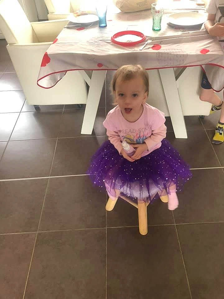 Amaya participe au concours pour gagner de l'argent avec cette photo : ballet_tutu, child, costume, dance, floor, flooring, fun, party, person, purple, room, shoe, table, toddler