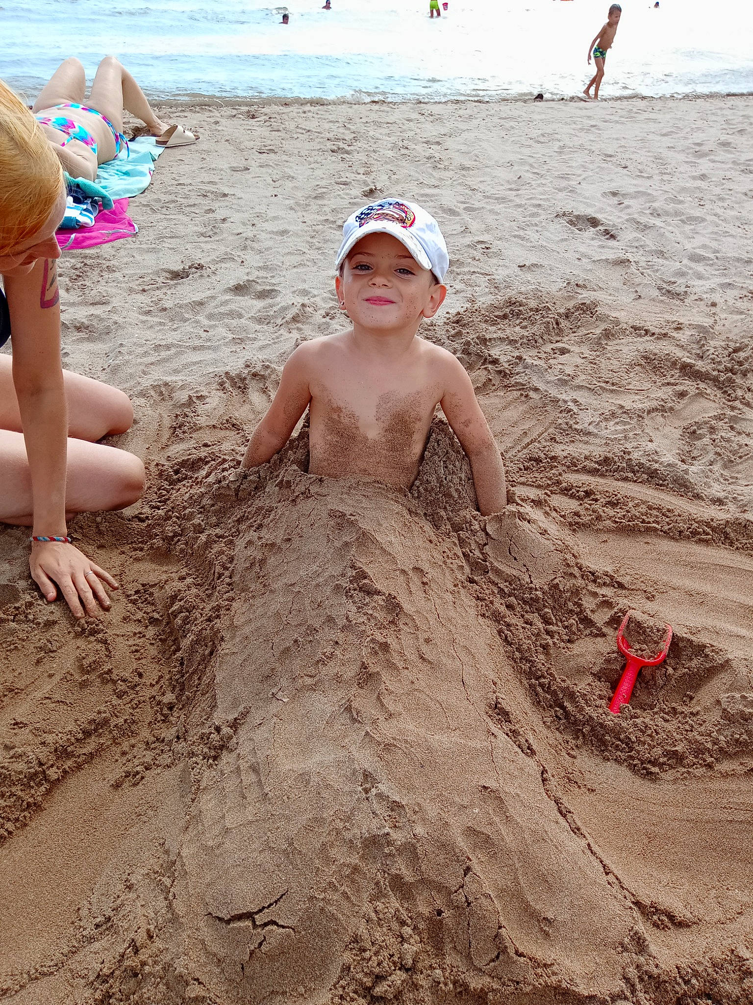Kennedy participe au concours pour gagner de l'argent avec cette photo : beach, brassiere, foot, fun, hat, headwear, human_body, human_leg, joy, leg, ocean, people_in_nature, people_on_beach, person, recreation, sand, sitting, soil, summer, swimwear