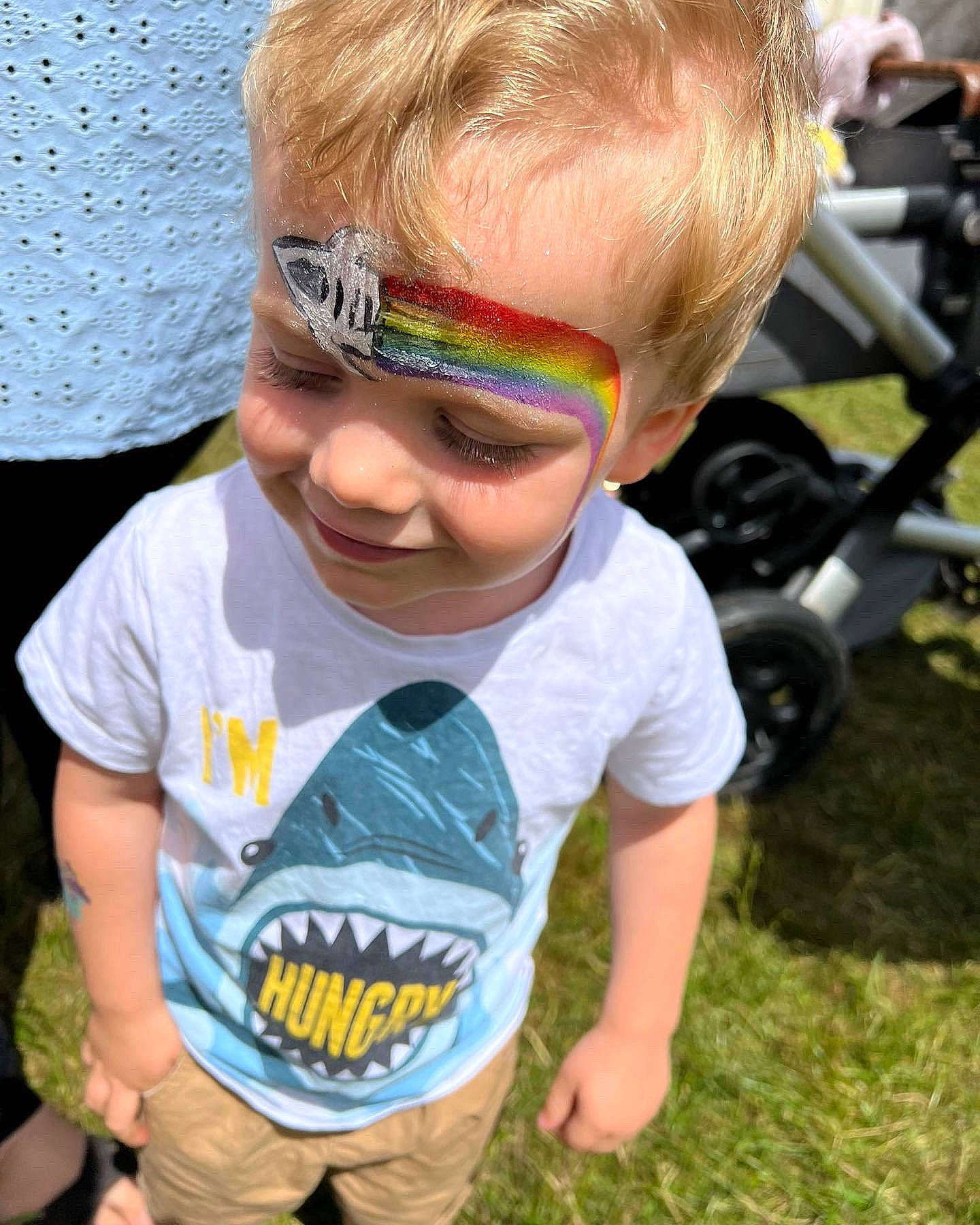 Noah is registered to the contest to win money with this photo: blue, child, cool, eyewear, fun, goggles, grass, hairstyle, happy, joy, leisure, people, person, personal_protective_equipment, smile, summer, sunglasses, tire, toddler, vision_care