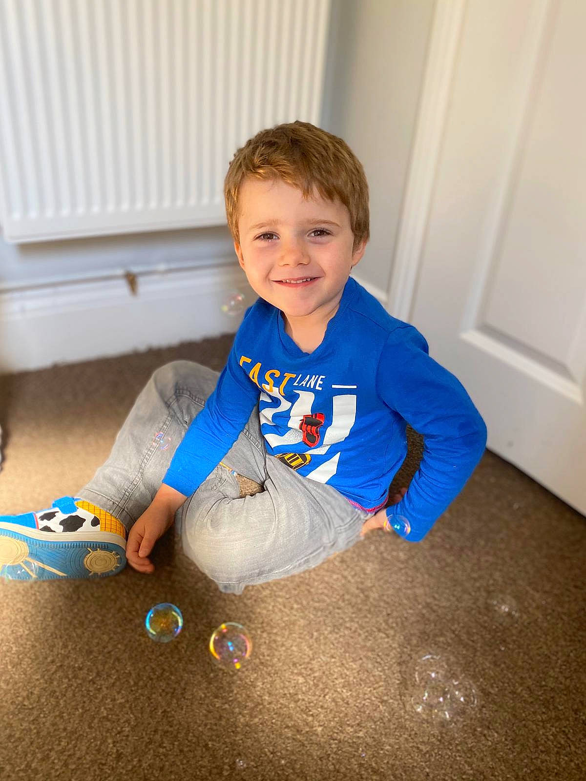 Leo-james is registered to the contest to win money with this photo: baby, baby_toddler_clothing, child, door, electric_blue, eye, floor, flooring, fun, hand, happy, iris, joy, pattern, person, play, sitting, sleeve, smile, t_shirt