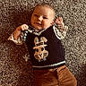 baby, child, infant, carpet, clothing, sweater_vest, bunny_design, pacifier, smile, happy, cute, lying_down, indoors, toddler, portrait, person, head, hands, brown_pants, plaid_shirt