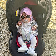 Helyana participe au concours pour gagner de l'argent avec cette photo : baby, infant, car_seat, stroller, sunglasses, pacifier, bonnet, white_shoes, socks, outdoor, gravel, sunlight, harness, jacket, cute, seat, headwear, accessory, cherry_print, portrait
