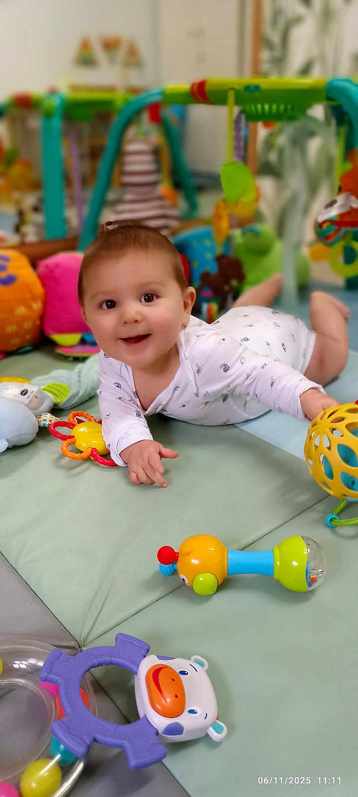 Noélan a rejoint le concours — aidez-le/la à gagner de superbes lots ! baby, smiling, indoor, play_mat, toys, colorful, child, happy, crawling, face, clothing, floor, soft_toys, rattle, infant, cute, playtime, young_child, home, person