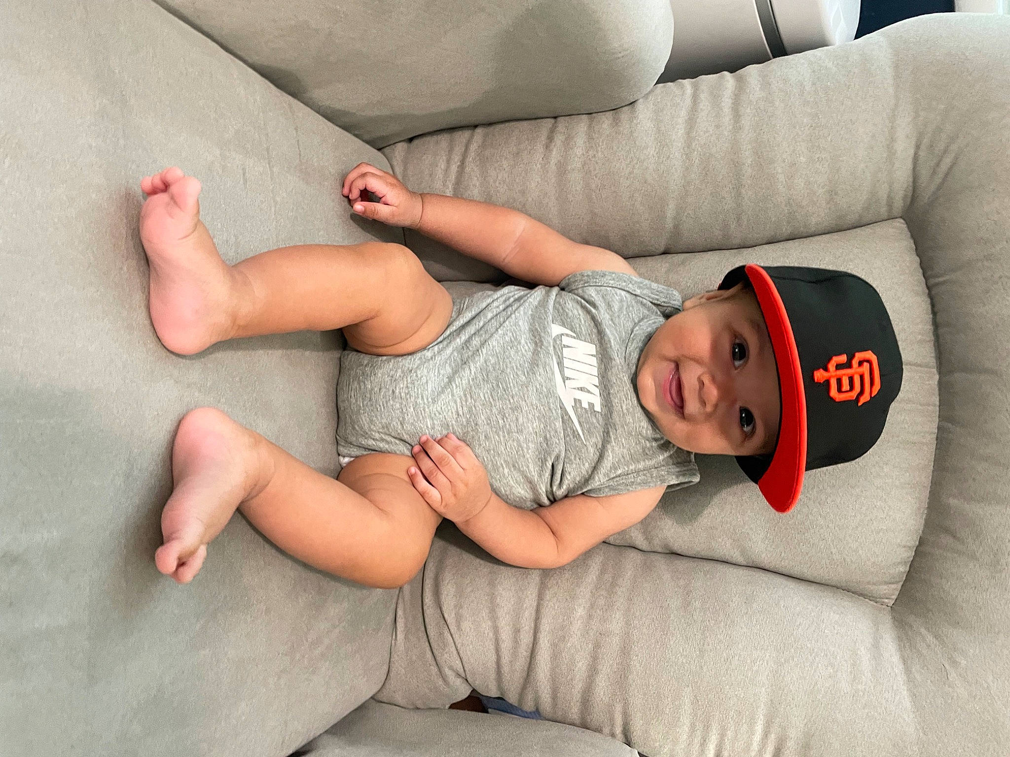 Cruz joined the competition — help win amazing prizes! baby, baby_toddler_clothing, child, comfort, couch, elbow, facial_expression, finger, headwear, human_body, human_leg, joint, knee, lap, mouth, muscle, person, sitting, skin, sleeve