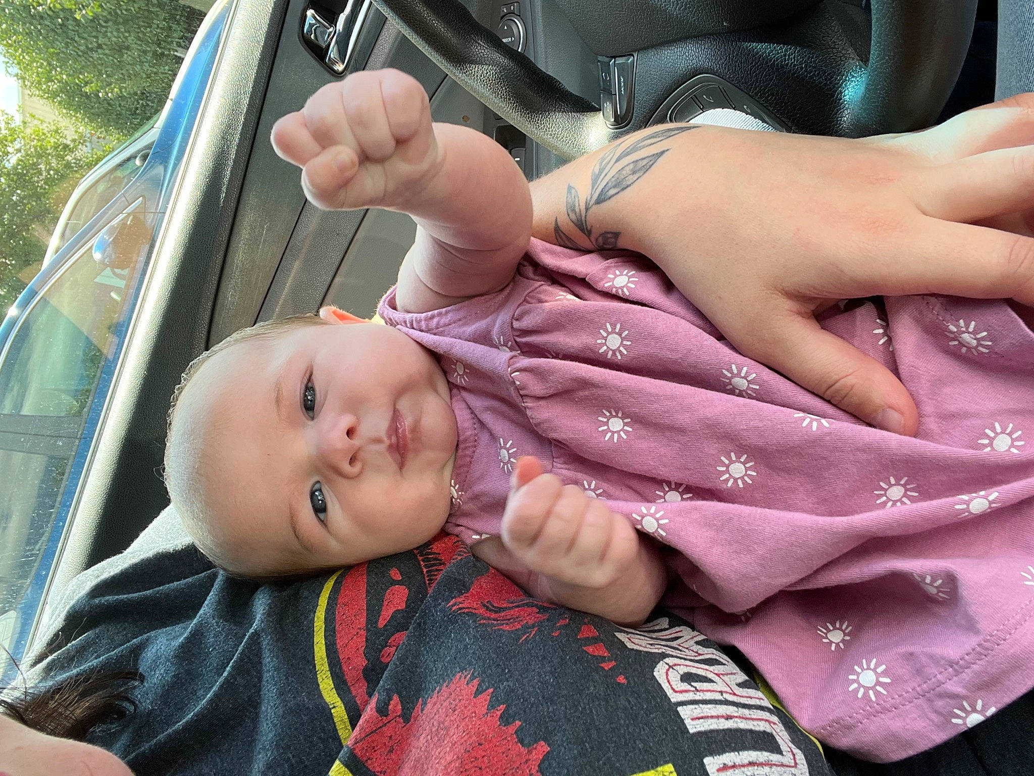 Maizey is registered to the contest to win money with this photo: automotive_exterior, baby, child, cool, finger, fun, gesture, grass, hand, happy, leisure, mouth, nail, person, skin, smile, thumb, toddler, tree, vehicle_door