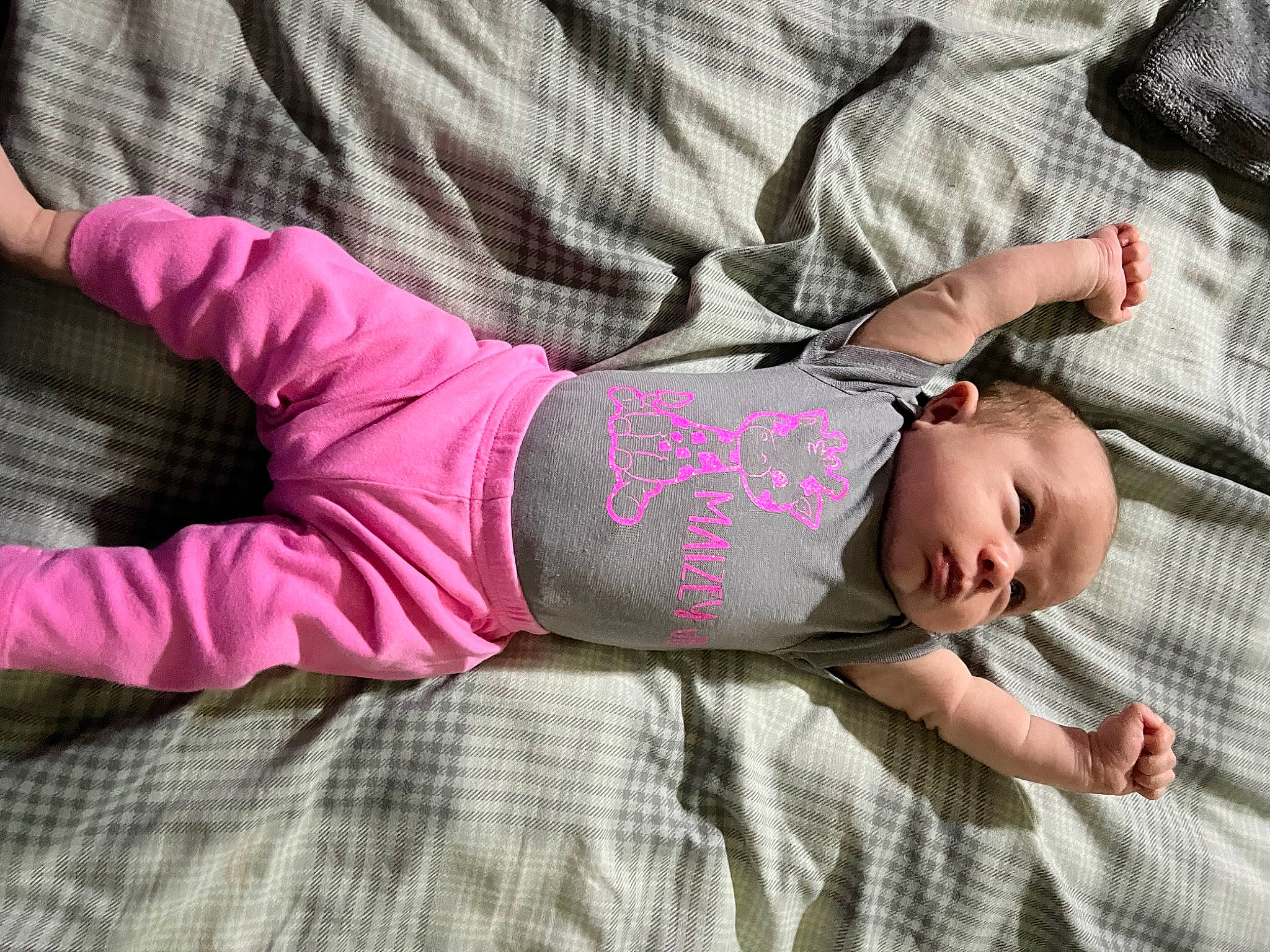Maizey is registered to the contest to win money with this photo: arm, baby, baby_toddler_clothing, comfort, elbow, finger, glasses, hand, human_body, human_leg, knee, leg, linens, pattern, person, pink, skin, sleeve, textile, thigh