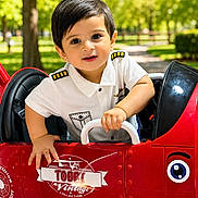 Muhammad Taha is registered to the contest to win money with this photo: boy, child, driver, face, happy, outdoor, park, pilot_costume, playground, portrait, red_car, sitting, smiling, steering_wheel, sunlight, toddler, toy_car, trees, uniform, vehicle