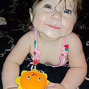 Adalina joined the competition — help win amazing prizes! baby, bed, blanket, blue_eyes, child, cute, drool, face, happy, indoor, infant, person, pink_clothing, playful, portrait, smiling, sun_shaped_toy, toy, yellow_toy, young_child