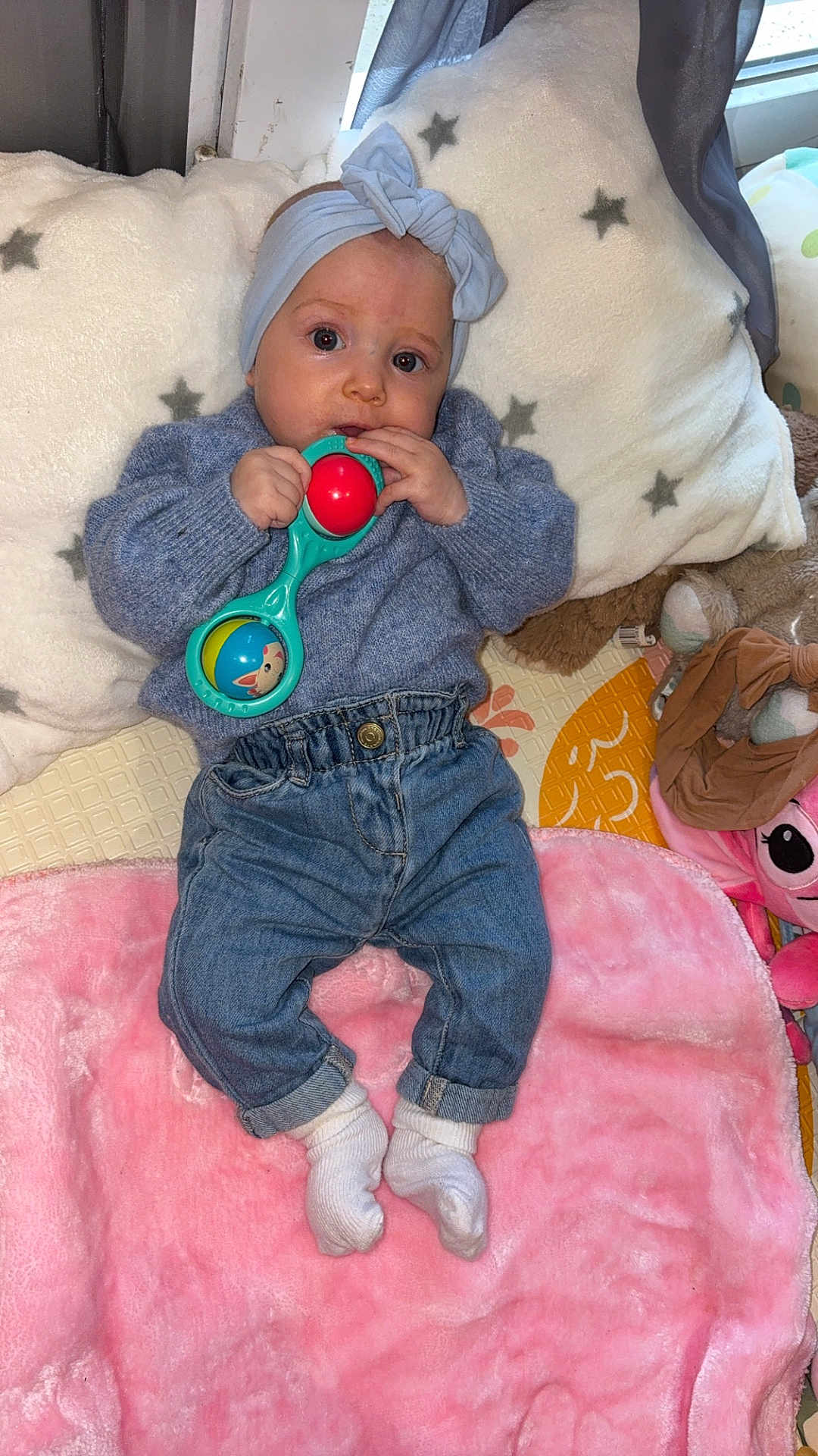Yeliz a rejoint le concours — aidez-le/la à gagner de superbes lots ! baby, headband, rattle, blue_sweater, jeans, white_socks, pink_blanket, pillow, star_pattern, toy, indoor, child, infant, cute, lying_down, soft_texture, colorful, cozy, portrait, playtime