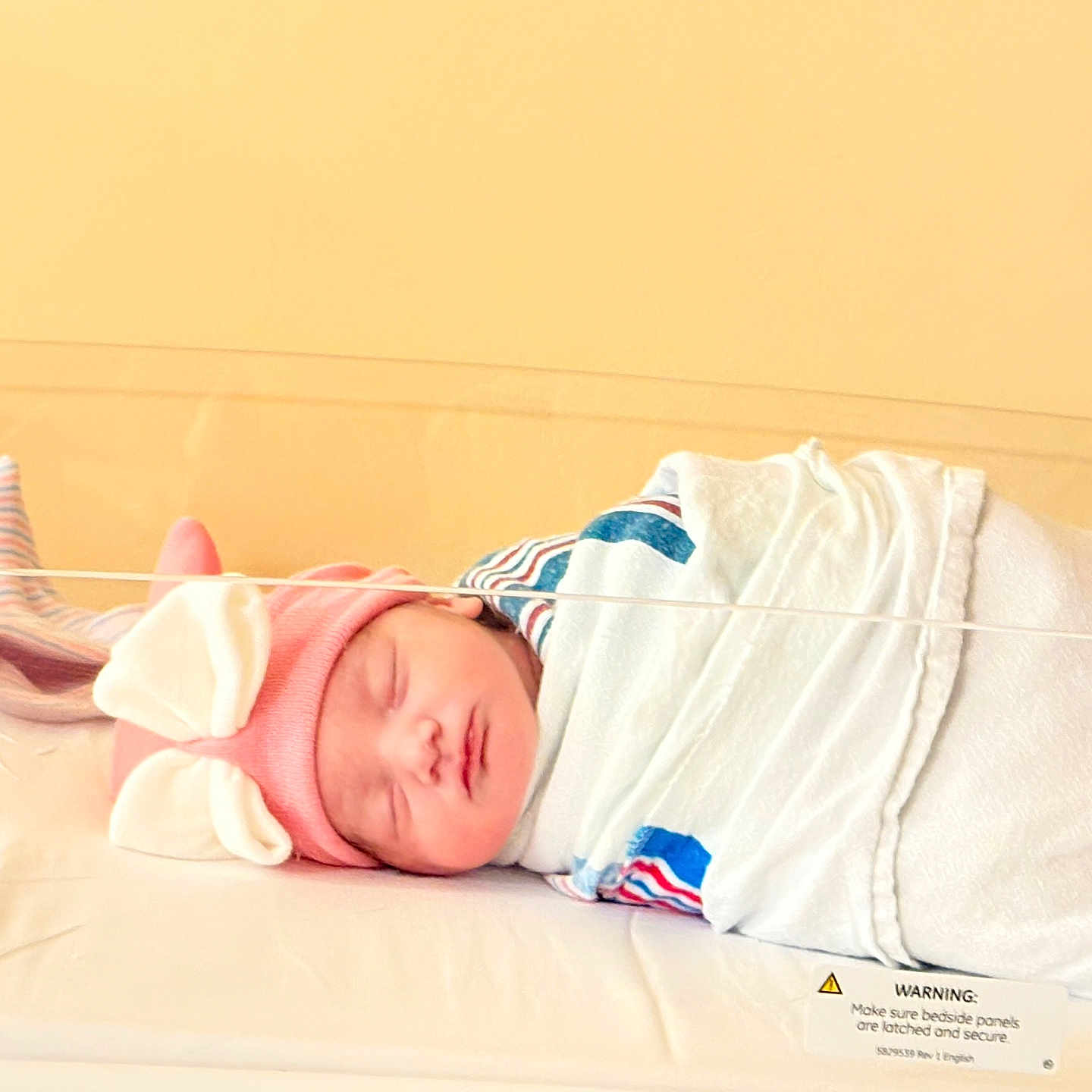 Thalia joined the competition — help win amazing prizes! baby, bassinet, blanket, bunny_ears, child, cute, face, headwear, healthcare, hospital, indoors, infant, newborn, peaceful, person, pink_hat, resting, sleeping, soft_light, wrapped