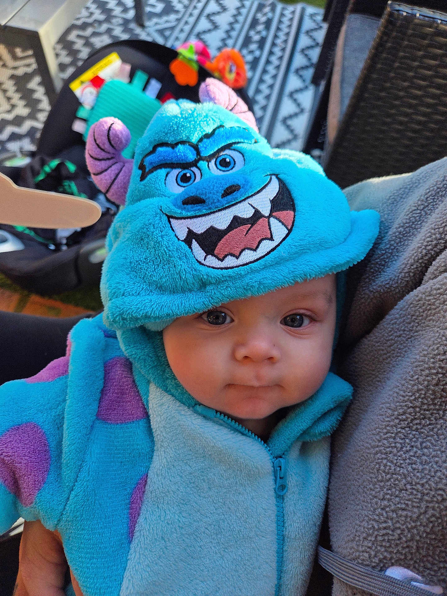 Marley is registered to the contest to win money with this photo: baby, child, costume, hood, blue, purple, face, eyes, person, clothing, fleece, hand, indoor, pattern, carseat, toy, fabric, zipper, cute, portrait