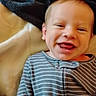Kane is registered to the contest to win money with this photo: baby, bed, blanket, candid, child, close_up, cozy, face, happy, home, indoors, infant, laughing, onesie, portrait, red_hair, sitting, smiling, soft_lighting, striped_clothing