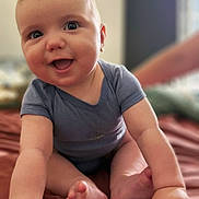 Glenn a rejoint le concours — aidez-le/la à gagner de superbes lots ! baby, infant, smiling, crawling, blue_onesie, happy, face, skin, hands, feet, indoors, bed, blanket, soft, cute, child, portrait, closeup, young, person