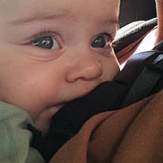 Aïssa a rejoint le concours — aidez-le/la à gagner de superbes lots ! baby, close_up, face, child, infant, carrier, straps, biting, skin, light, person, cute, young, eyes, mouth, comfort, soft_light, clothing, human, portrait