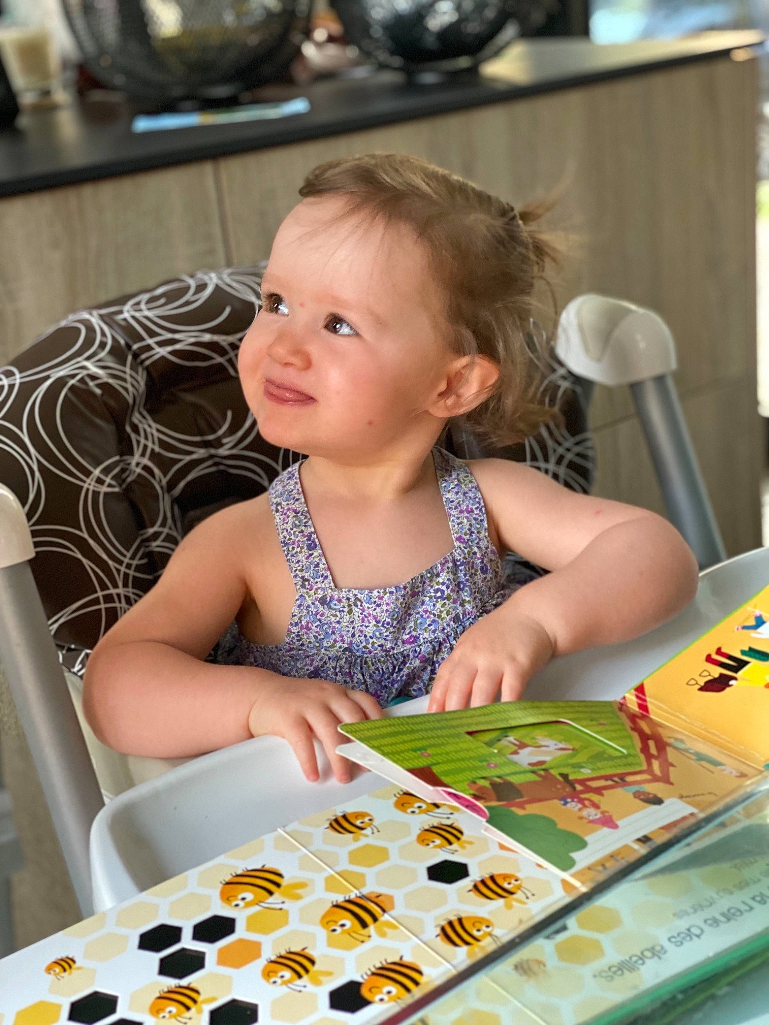 Ellie participe au concours pour gagner de l'argent avec cette photo : baby, baby_products, baby_toddler_clothing, chair, cheek, child, face, finger, flooring, fun, happy, head, person, play, sitting, skin, smile, sweetness, table, toddler