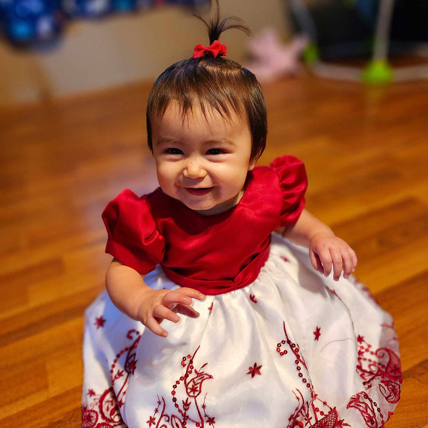 Aria joined the competition — help win amazing prizes! baby, black_shoes, child, cute, dress, embroidery, floor, girl, hair_bow, happy, indoor, person, playful, pony_tail, portrait, red_dress, sitting, smile, white_dress, wooden_floor